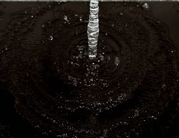 黒い背景に水が落ち — ストック写真