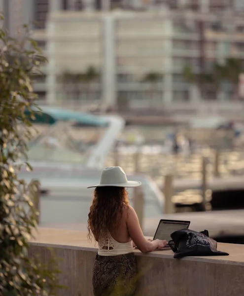 Νεαρή Γυναίκα Κάθεται Στον Πάγκο Και Χρησιμοποιεί Laptop Της — Φωτογραφία Αρχείου