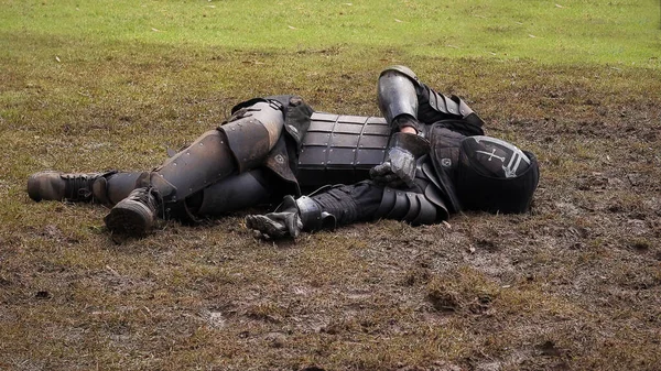 man in a black suit and a helmet with a gun on the background of the field