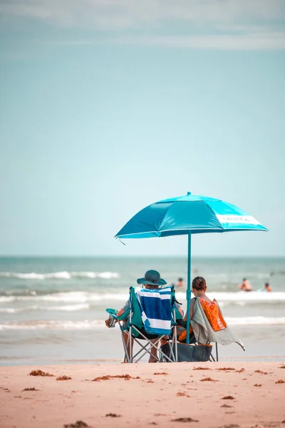 Sombrilla de playa a rayas en la playa sombrilla de playa en un día soleado  mar de fondo azul