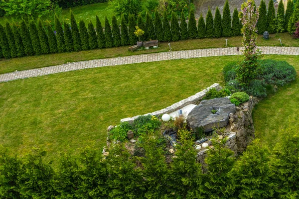 Zielony Trawnik Dużą Kamienną Ścianą — Zdjęcie stockowe