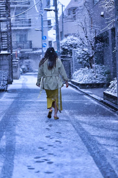 冬のコートを着た若い女性が街を歩き — ストック写真