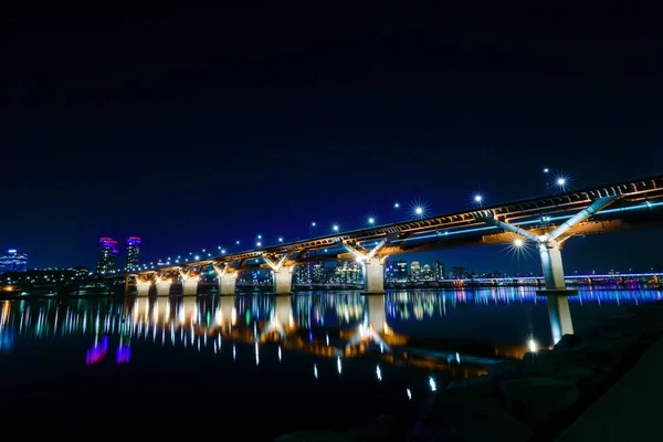 晚上俯瞰这座桥的城市 — 图库照片