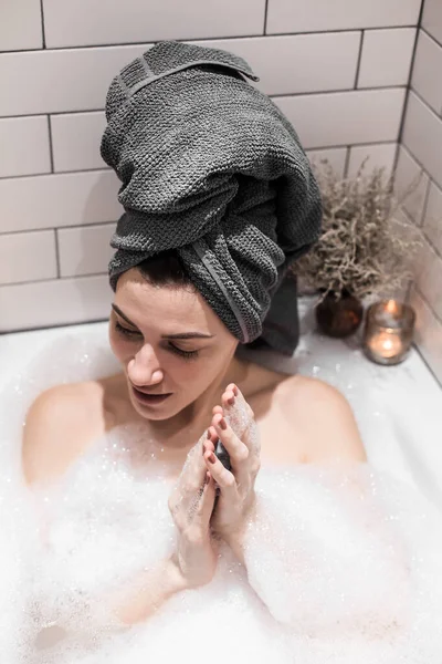 年轻美丽的女人沐浴在肥皂泡里 — 图库照片