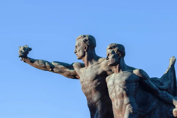 statue of  men on blue sky background