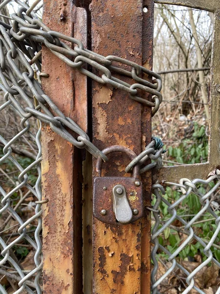 old rusty padlock on the background of the fence