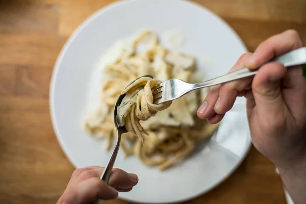 Donna Che Mangia Pasta Con Forchetta Cucchiaio Sul Tavolo Legno — Foto Stock