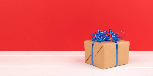 Pudełko Czerwoną Wstążką Niebieskim Tle Przestrzeń Kopiowania — Zdjęcie stockowe