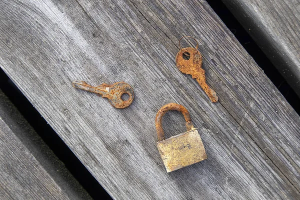 旧挂锁和木制背景上的键 — 图库照片
