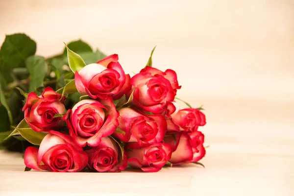 木制背景上的一束美丽的红玫瑰 — 图库照片