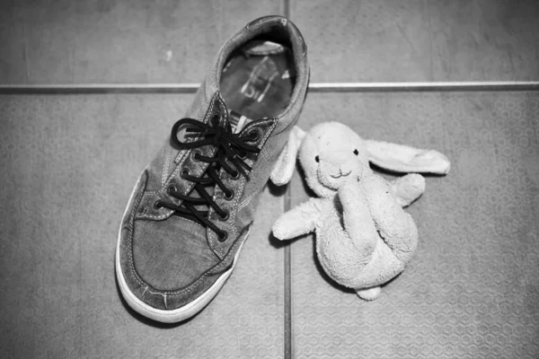 古い黒と白の赤ちゃんの靴を木の背景に — ストック写真
