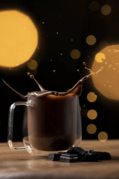 シナモンスティックとミルクの入ったコーヒーカップが暗い背景にあります — ストック写真