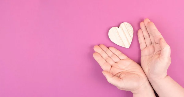 Manos Sosteniendo Corazón Rosa Sobre Fondo Púrpura — Foto de Stock