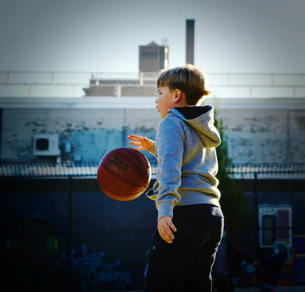 裁判所でバスケットボールをしている少年 — ストック写真