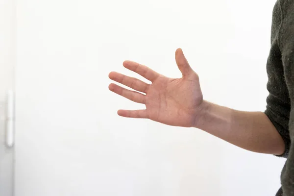 Fechar Uma Mão Segurando Uma Parede Branca Com Fundo Borrado — Fotografia de Stock
