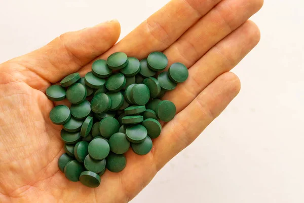 Πράσινα Χάπια Ένα Χέρι Λευκό Φόντο — Φωτογραφία Αρχείου