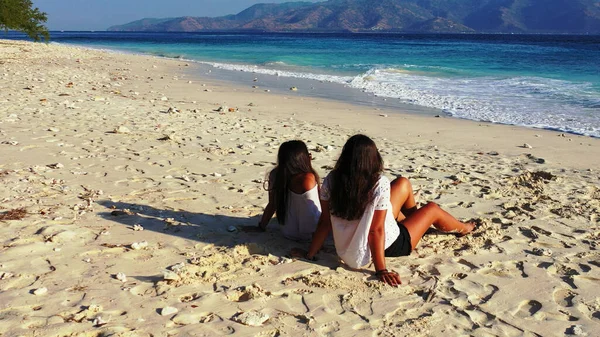 Due Ragazze Sedute Sulla Spiaggia Guardando Fotocamera — Foto Stock