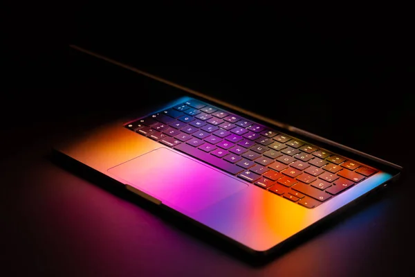 黑色背景上带有发光霓虹灯的笔记本电脑 — 图库照片