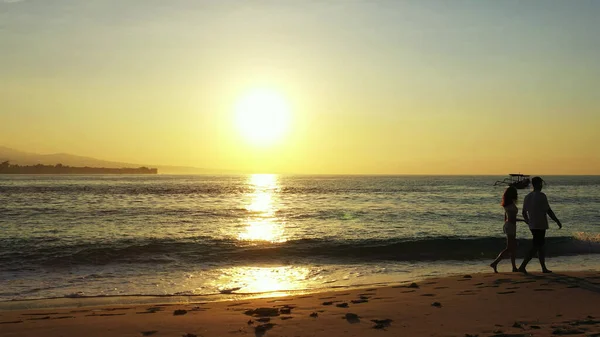 日落时一对夫妇在海滩上的轮廓 — 图库照片