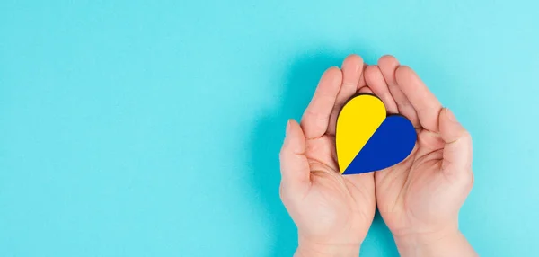 Conceito Mãos Humanas Segurando Bandeira Ucraniana Forma Coração Fundo Azul — Fotografia de Stock