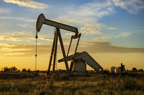 日没時の石油ポンプとガスタンク — ストック写真