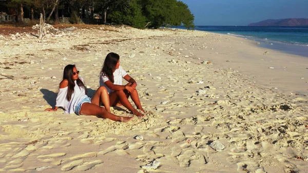 Due Ragazze Sedute Sulla Spiaggia Guardando Fotocamera — Foto Stock