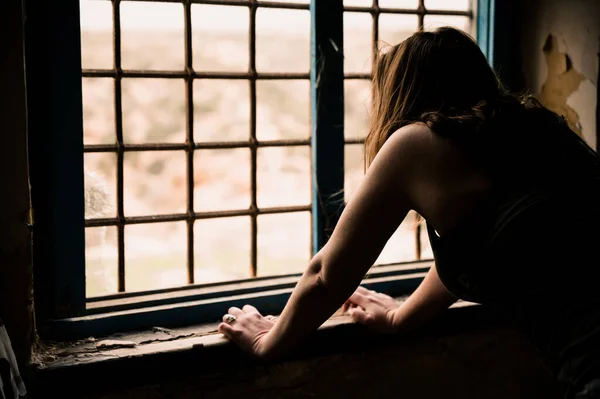 Genç Bir Kadın Pencerede Oturuyor Kameraya Bakıyor — Stok fotoğraf
