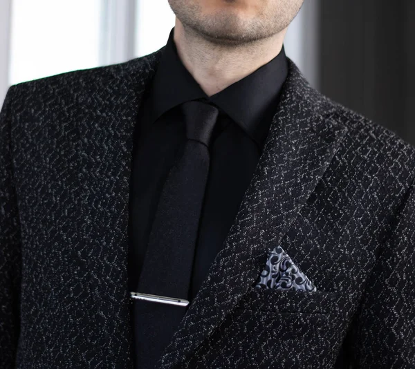 Ofiste siyah takım elbiseli bir iş adamı var.