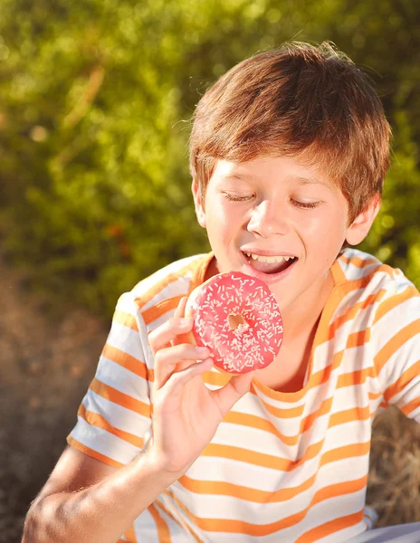 Kind donut eten — Stockfoto