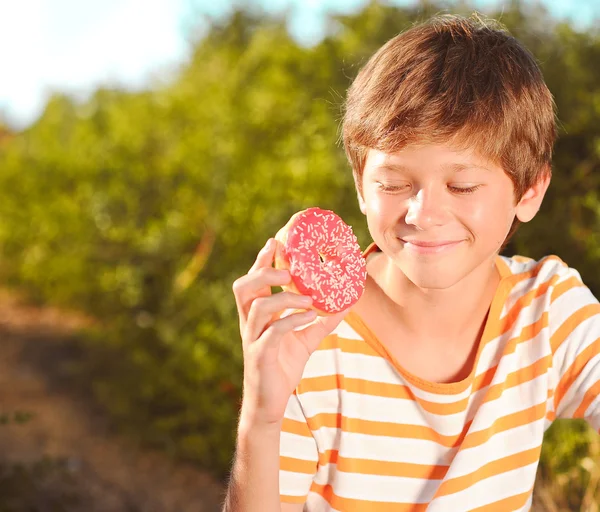 Niño feliz sosteniendo donut —  Fotos de Stock