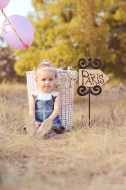 Paris işareti ile oturan kız bebek