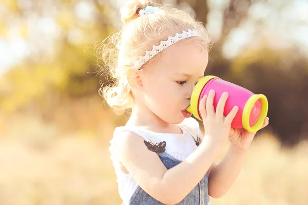 Dziecko dziewczynka wody pitnej z plastikowy kubek — Zdjęcie stockowe