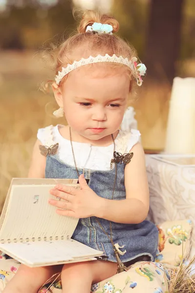 Petite fille lecture livre en plein air — Photo