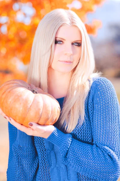 Smiling girl with pumpkin outdoors — Stock Photo, Image