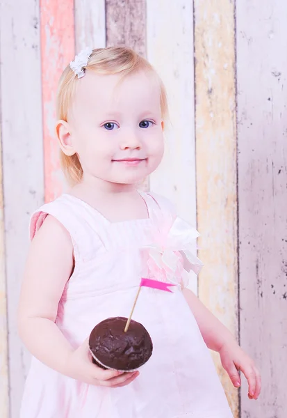 Schattige baby meisje bedrijf cupcake — Stockfoto