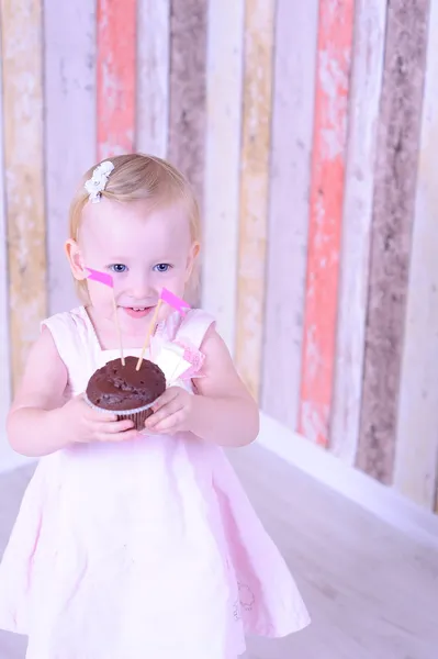 Baby girl with chocolate cupcakes — Stock Photo, Image
