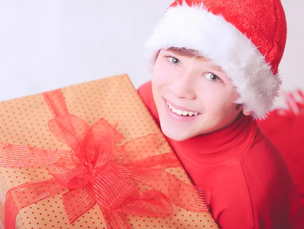 Smiling child holding christmas presents indoors — Stockfoto