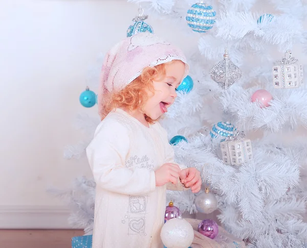 Riéndose niña sosteniendo la bola de Navidad en la habitación — Foto de Stock