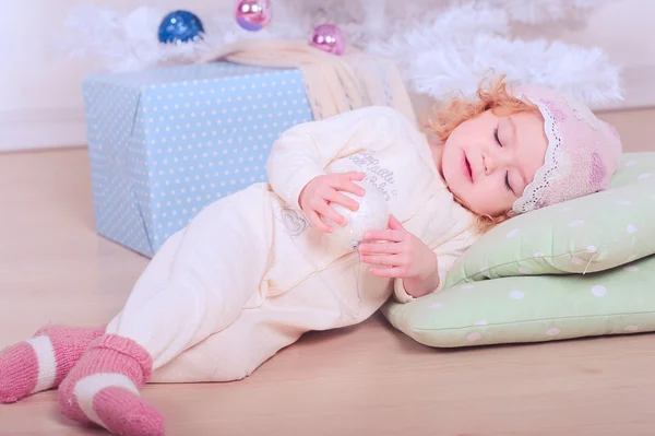 Schattige babymeisje liggend op de vloer met Kerstmis bal — Stockfoto