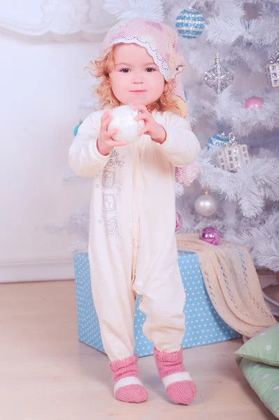 Happy baby girl in pajamas with christmas ball — Stock Photo, Image