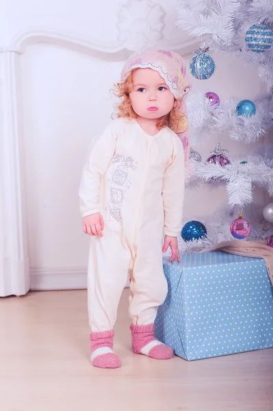 Schattige babymeisje in pyjama met kerstboom — Stockfoto