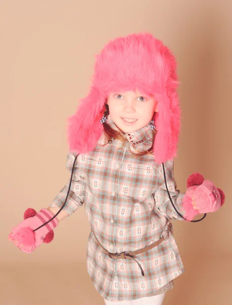 Милая маленькая девочка в меховой шапке в студии — стоковое фото