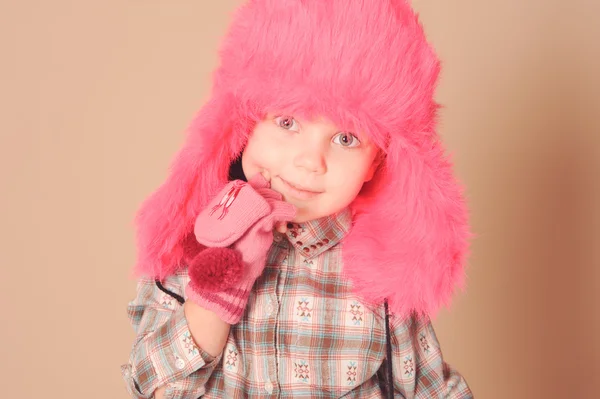 Милая маленькая девочка в меховой шапке в студии — стоковое фото