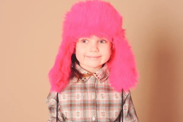 Smiling baby girl wearing fur hat in studio — Stock Photo, Image