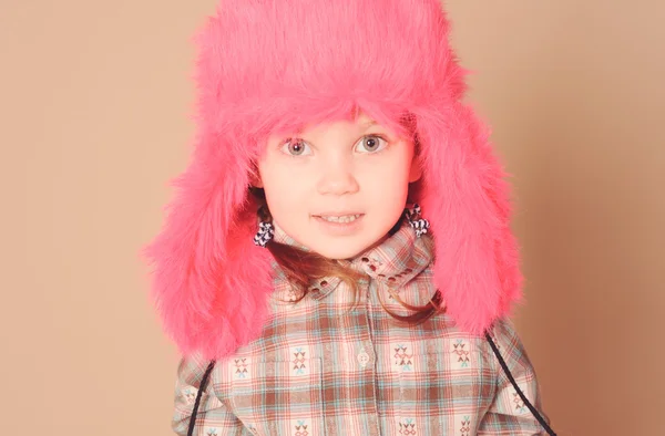 Smiling baby girl wearing fur hat in studio — Stock Photo, Image