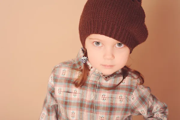 Cute little girl wearing knitted hat in studio — Stock Photo, Image