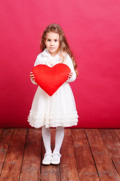 Cute girl holding valentine's pillow — Stock Photo, Image