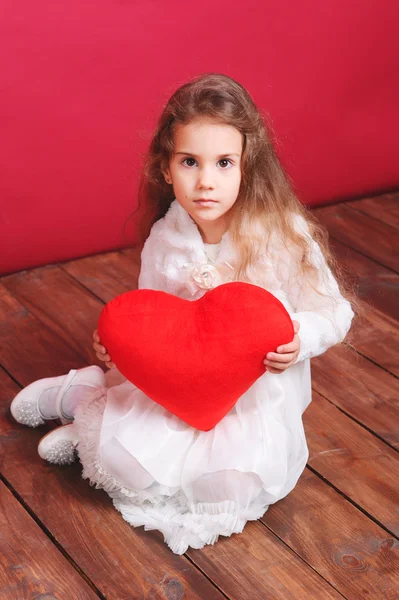 かわいい女の子の赤いバレンタインの心を保持しています。 — ストック写真