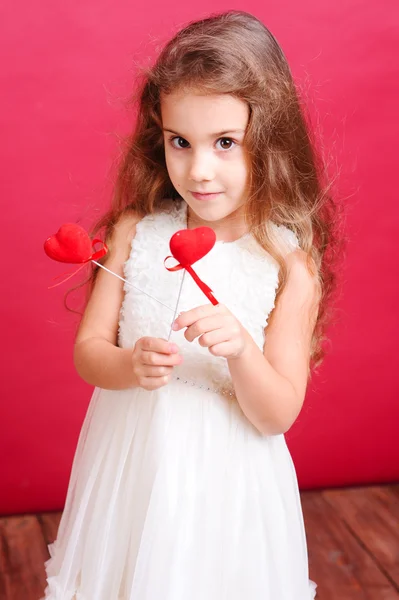 Cute little girl holding valentine's hearts Stock Picture