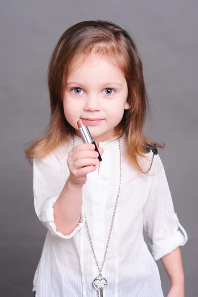 Menina bonito segurando batom — Fotografia de Stock